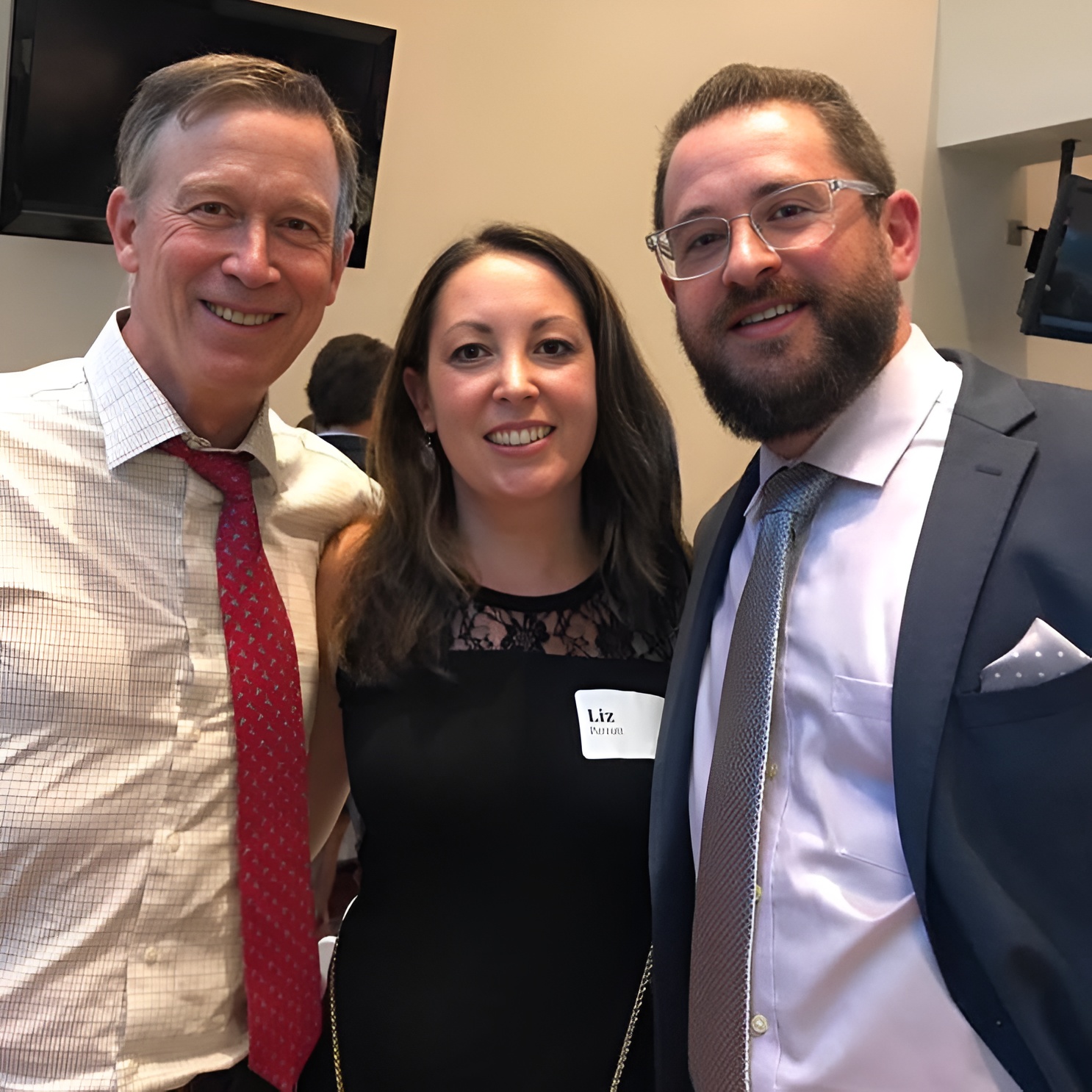 John Hickenlooper posing with the owners of 5280 Custom Framing at an event